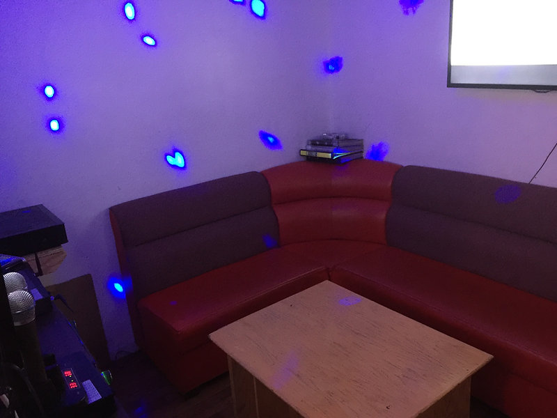 Small karaoke room with neon lights