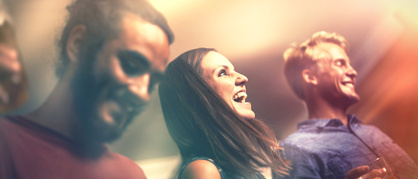 Three friends laughing together at a night out